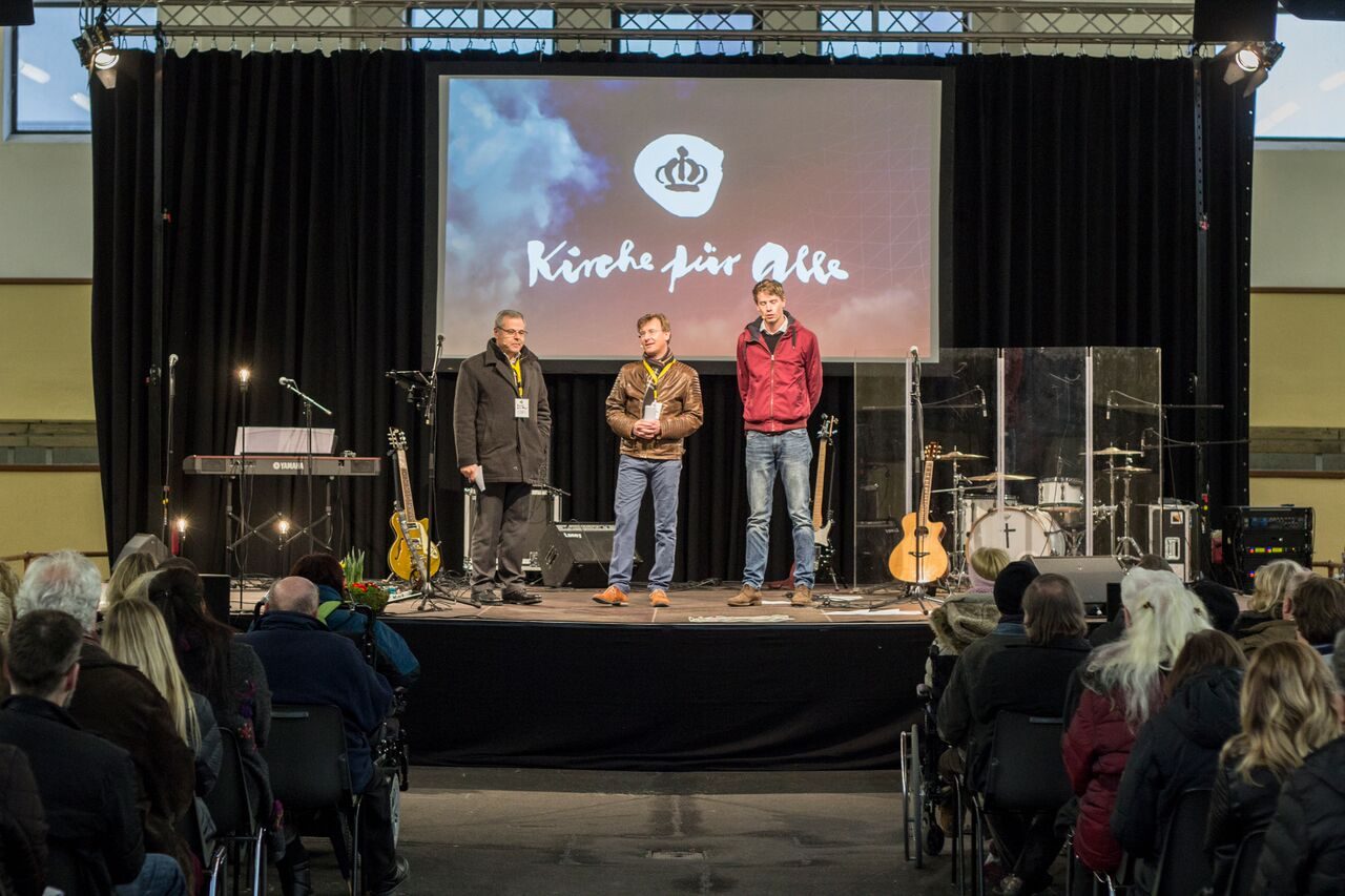 Bühne mit dem Schriftzug »Kirche für Alle« auf der Leinwand